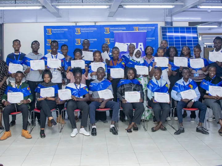 A graduating cohort holding their certificates at Strathmore University